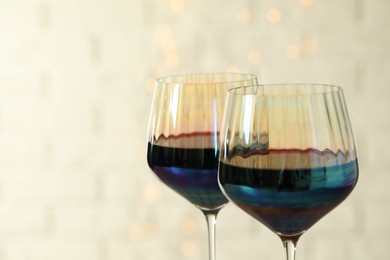Photo of Glasses of red wine on light background, closeup. Space for text