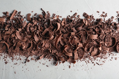 Chocolate curls on gray background, top view