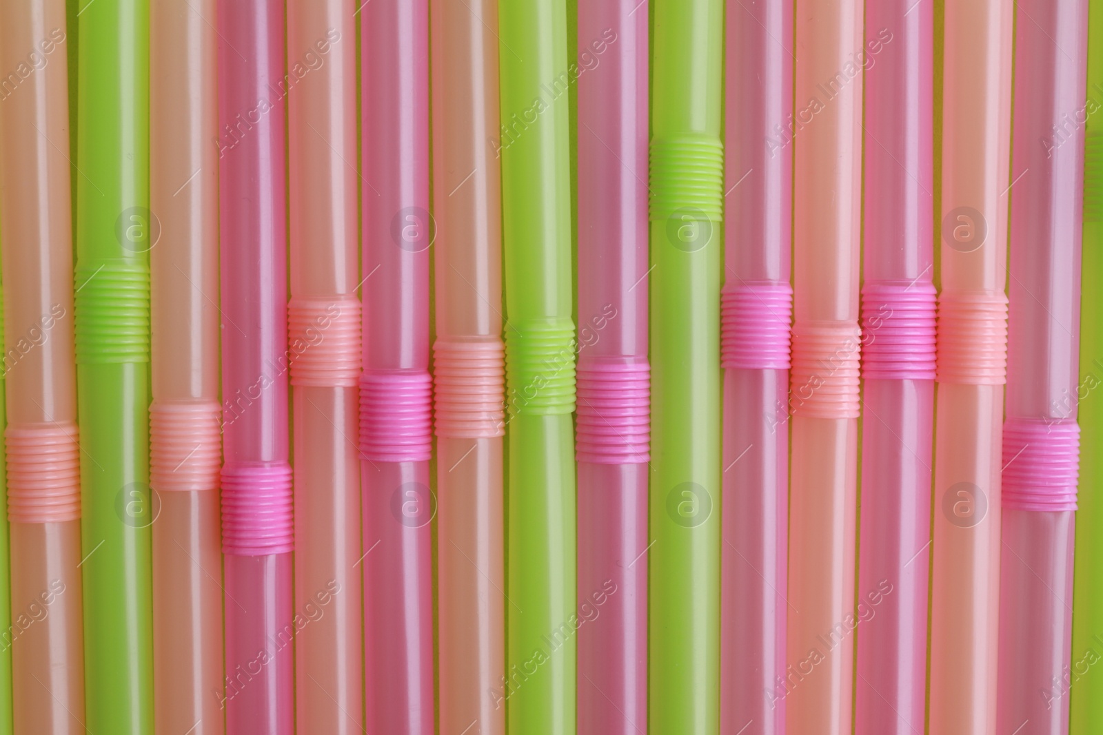 Photo of Colorful plastic straws as background, top view