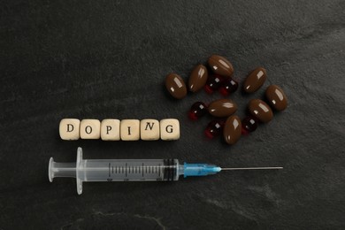 Wooden cubes with word Doping and drugs on black background, flat lay