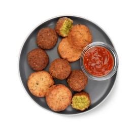 Photo of Plate with delicious vegan cutlets, falafel balls and sauce isolated on white, top view