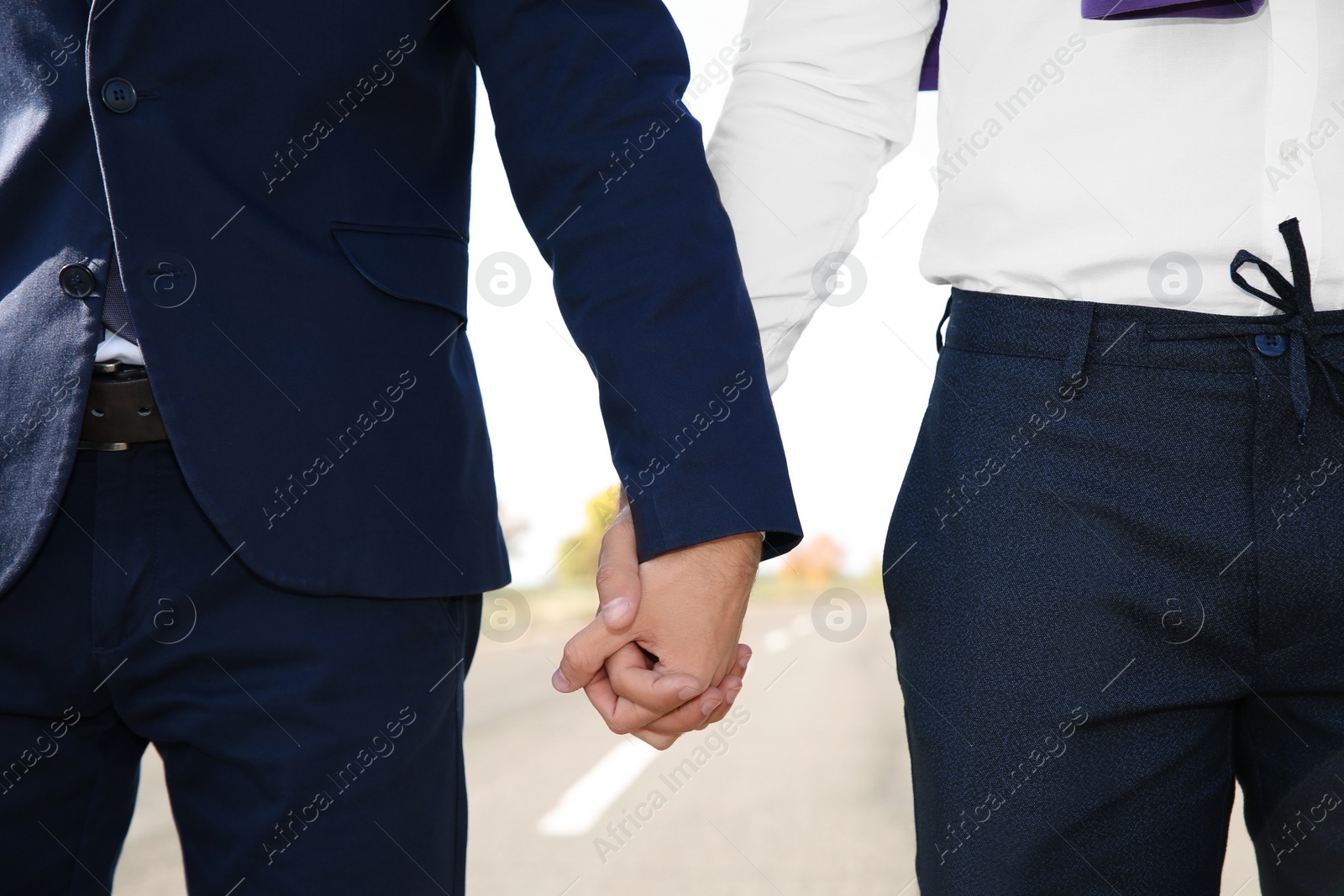 Photo of Gay couple holding hands outdoors, closeup view