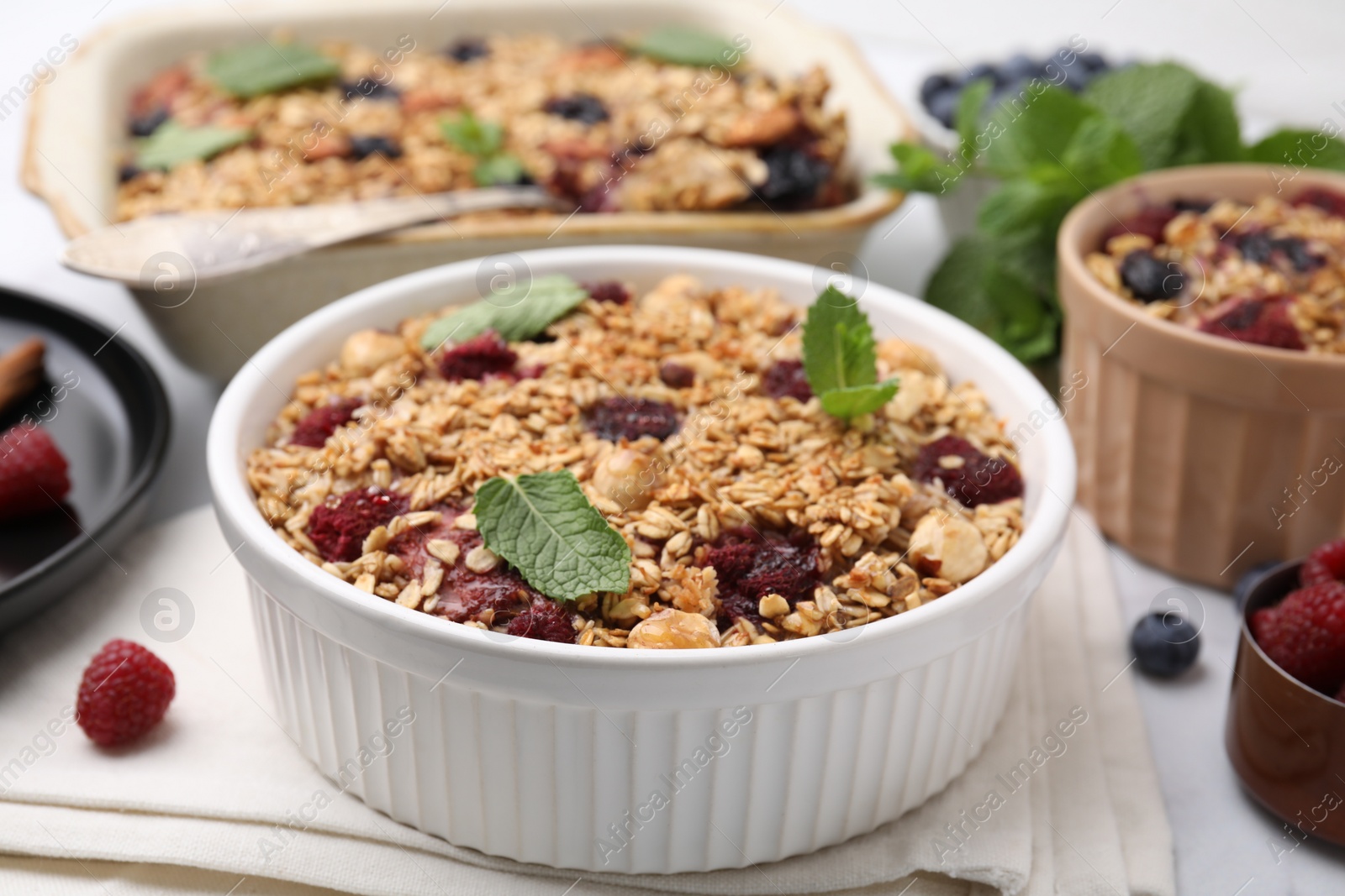 Photo of Tasty baked oatmeal with berries and nuts on table, closeup