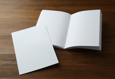 Sheet of paper and blank brochure on wooden table. Mockup for design