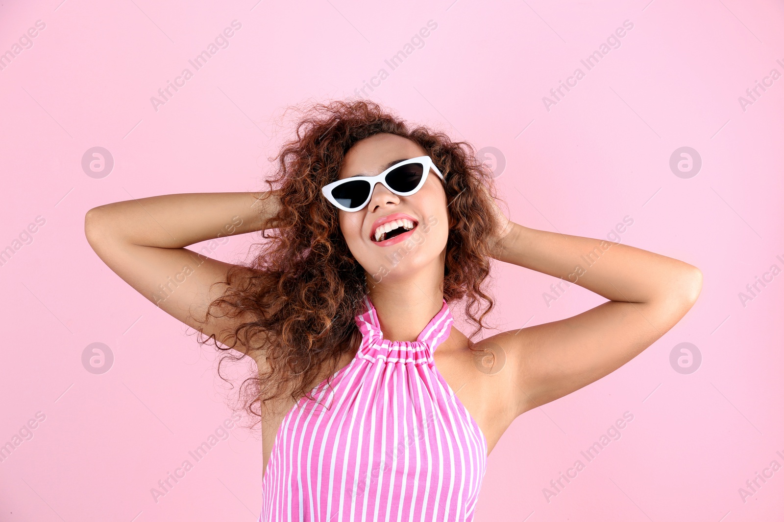 Photo of Portrait of laughing African-American woman with sunglasses on color background