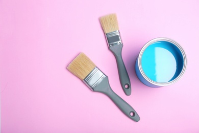 Photo of Flat lay composition with paint can and brushes on color background. Space for text