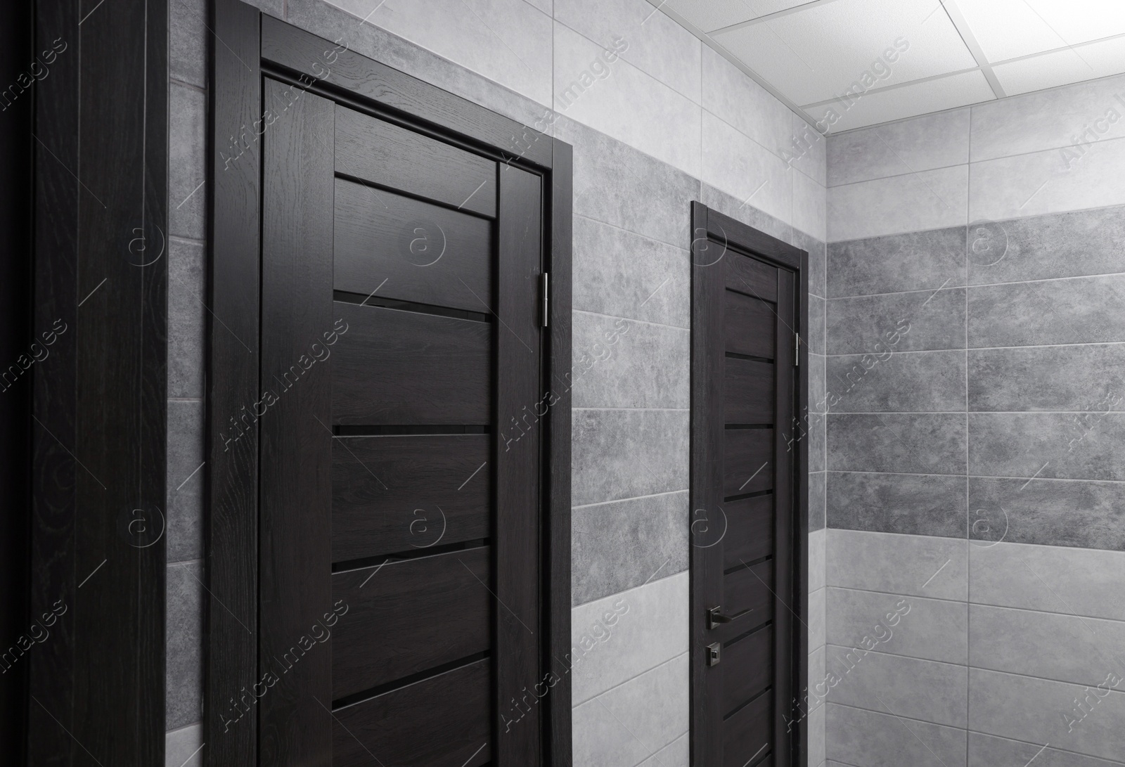 Photo of Public toilet interior with stylish doors and tiles