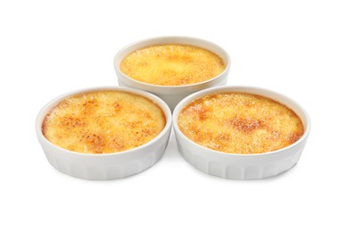 Photo of Delicious creme brulee in ceramic ramekins on white background