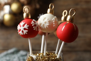 Photo of Delicious Christmas ball cake pops on blurred background, closeup