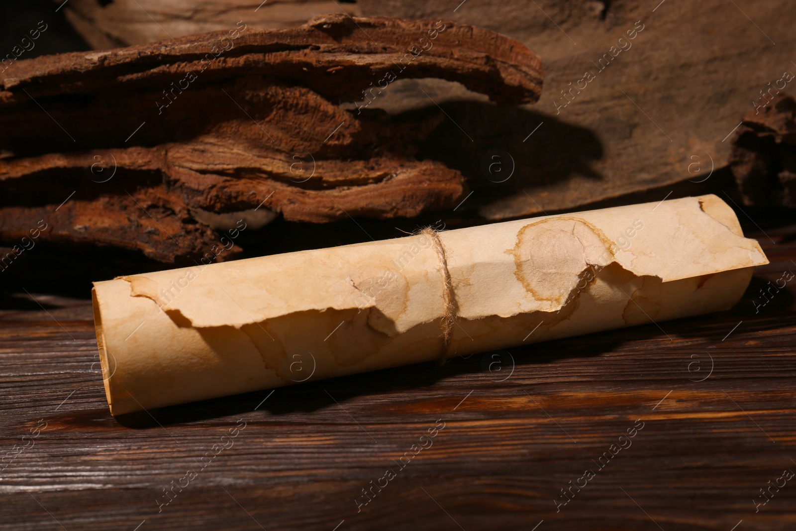 Photo of Scroll of old parchment paper on wooden table