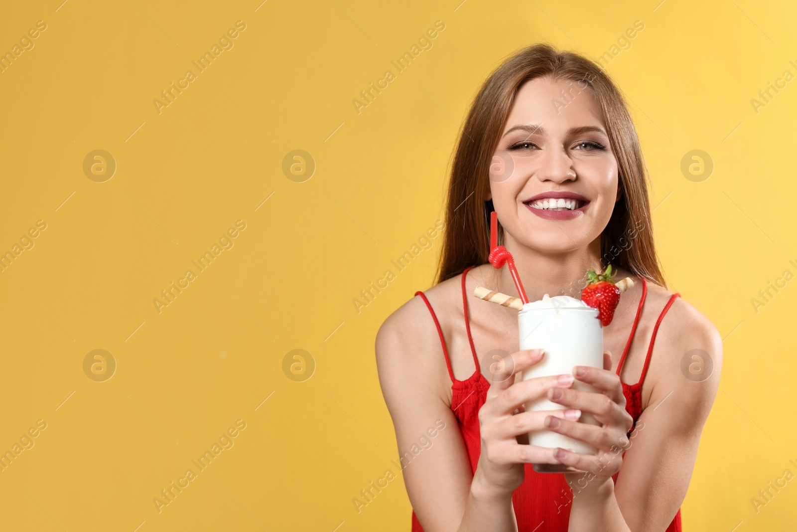 Photo of Young woman with glass of delicious milk shake on color background