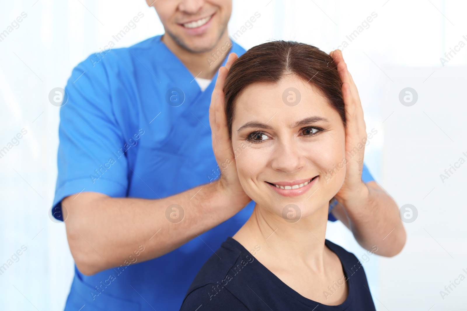 Photo of Physiotherapist working with patient in clinic. Rehabilitation therapy