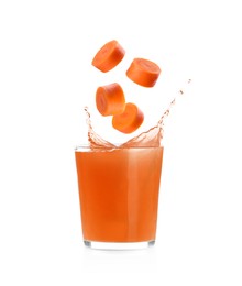 Image of Splashing freshly made carrot juice on white background. Cut carrot falling into glass