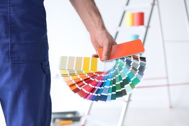Male decorator with color palette indoors, closeup