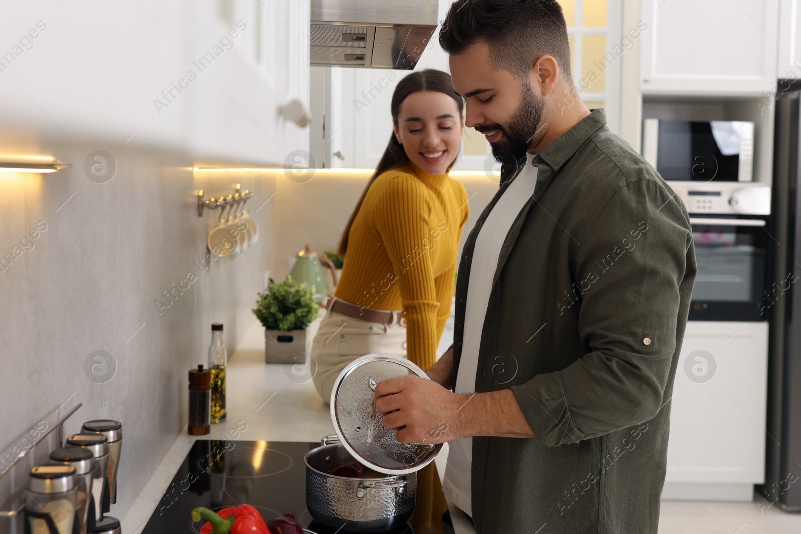 Photo of Lovely young couple cooking together in kitchen