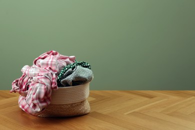 Photo of Laundry basket with clothes near light green wall. Space for text