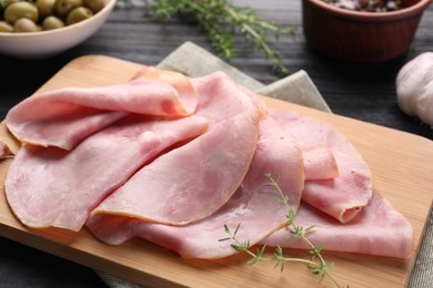 Photo of Slices of delicious ham with thyme on table, closeup