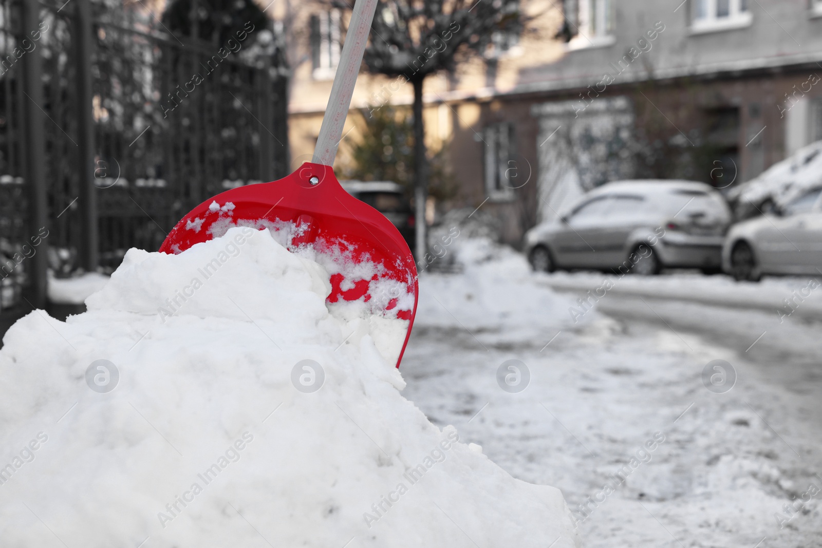 Photo of Shovel in snowdrift on city street. Space for text