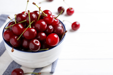 Photo of Sweet juicy cherries on white wooden table. Space for text