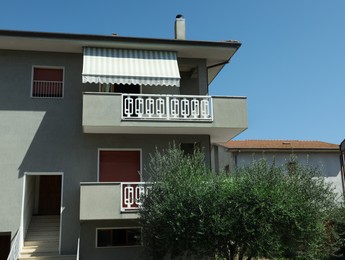 Exterior of residential building with balconies on sunny day