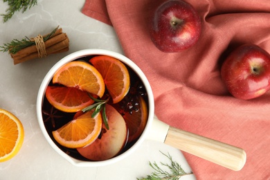 Tasty mulled wine with spices on light grey table, flat lay