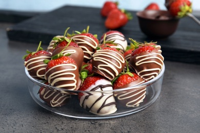 Photo of Plate with chocolate covered strawberries on table