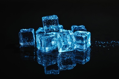 Photo of Pile of crystal clear ice cubes on black background