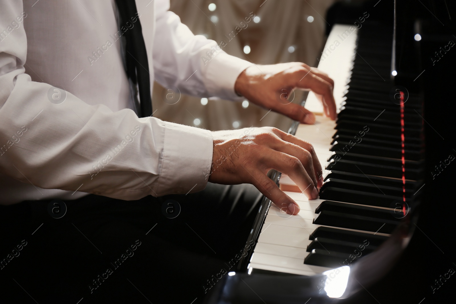 Photo of Man playing piano indoors, closeup. Talented musician
