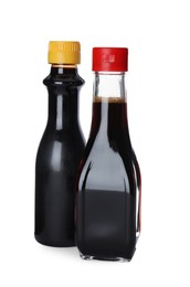 Photo of Bottles of tasty soy sauce isolated on white