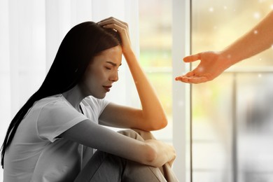 Image of Empathy. Man offering helping hand to depressed woman indoors, closeup. Transition from black and white to color on photo as symbol of emotional support