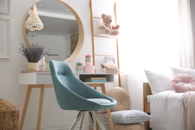 Photo of Comfortable blue chair in teenage girl's bedroom interior. Idea for design