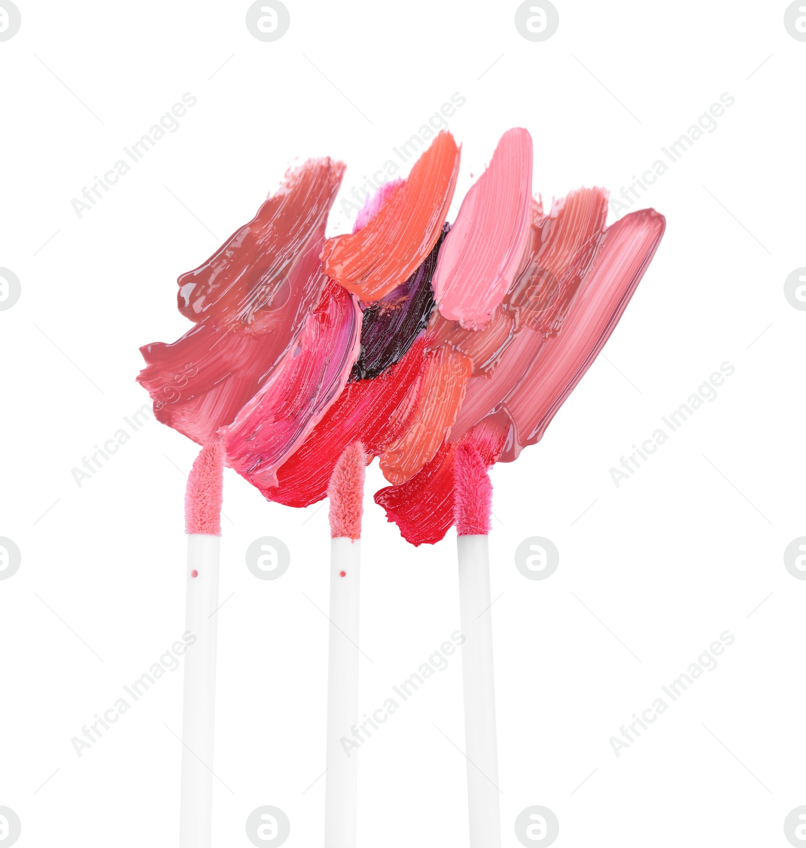 Photo of Strokes of different lip glosses and applicators isolated on white, top view