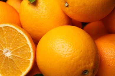 Photo of Many whole and cut oranges as background, closeup