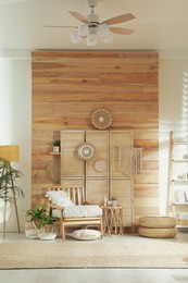 Photo of Stylish living room interior with comfortable wooden armchair and beautiful houseplants