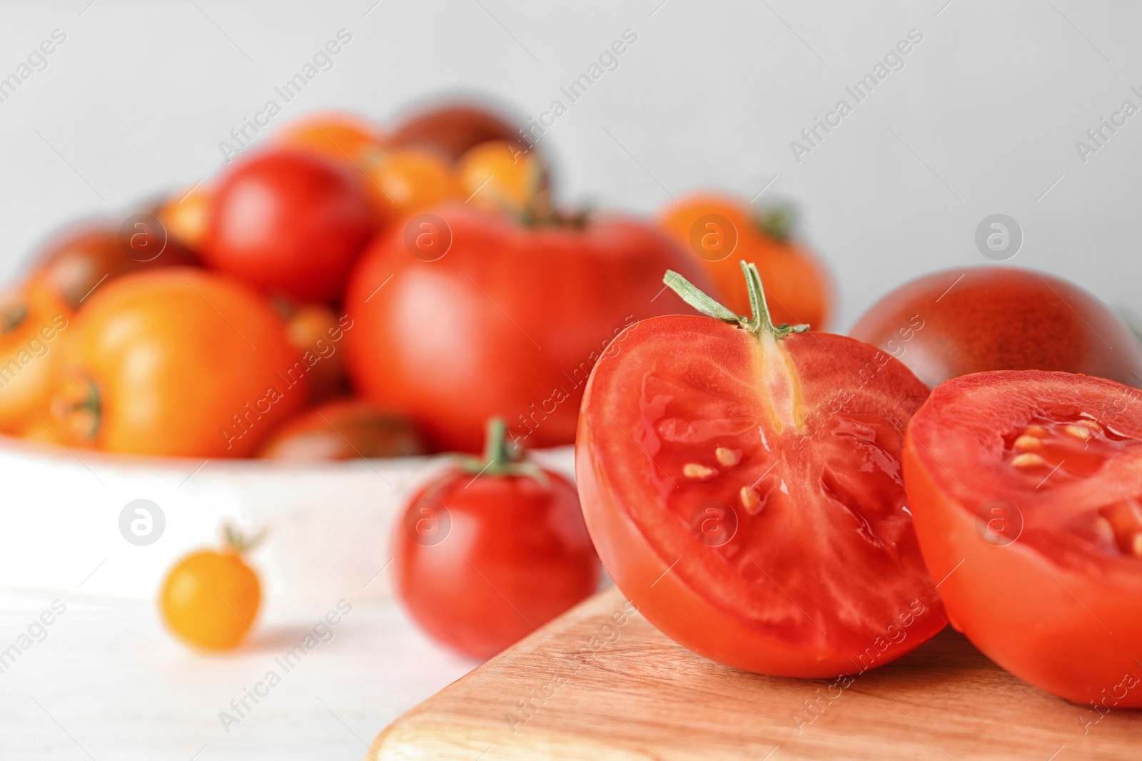 Photo of Fresh ripe tomatoes on wooden board, closeup. Space for text