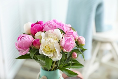 Photo of Bouquet of beautiful peonies in room, space for text