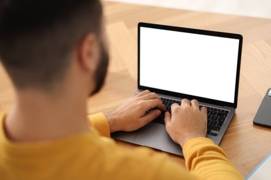 Photo of Young man watching webinar at table, closeup