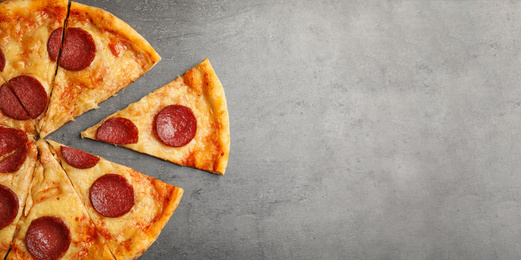 Photo of Tasty pepperoni pizza on grey table, flat lay. Space for text