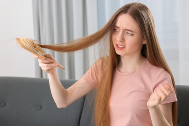 Photo of Upset woman brushing her hair at home. Alopecia problem