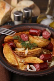 Photo of Delicious baked potato with thin dry smoked sausages, onion and dill in bowl on bowl, closeup