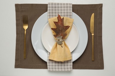 Photo of Autumn table setting and dry leaf, flat lay