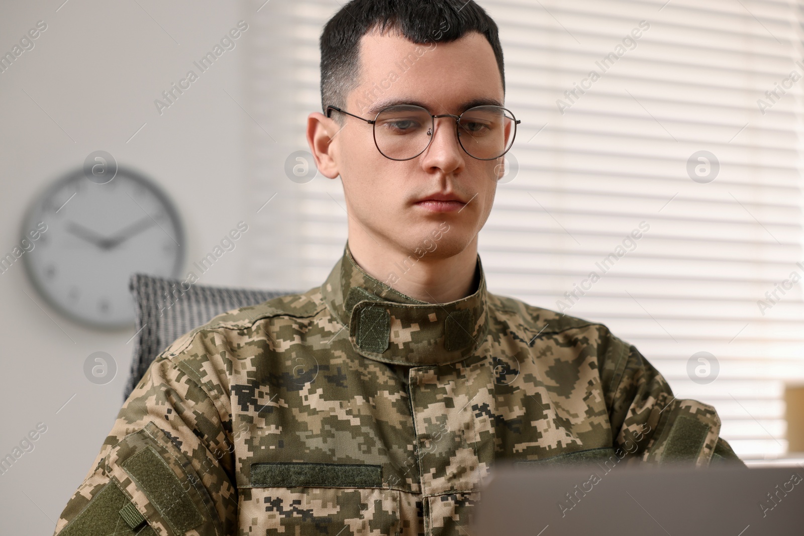 Photo of Military service. Young soldier working in office