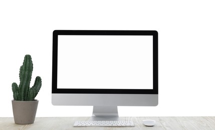 Photo of New computer with blank monitor screen and potted cactus on white background