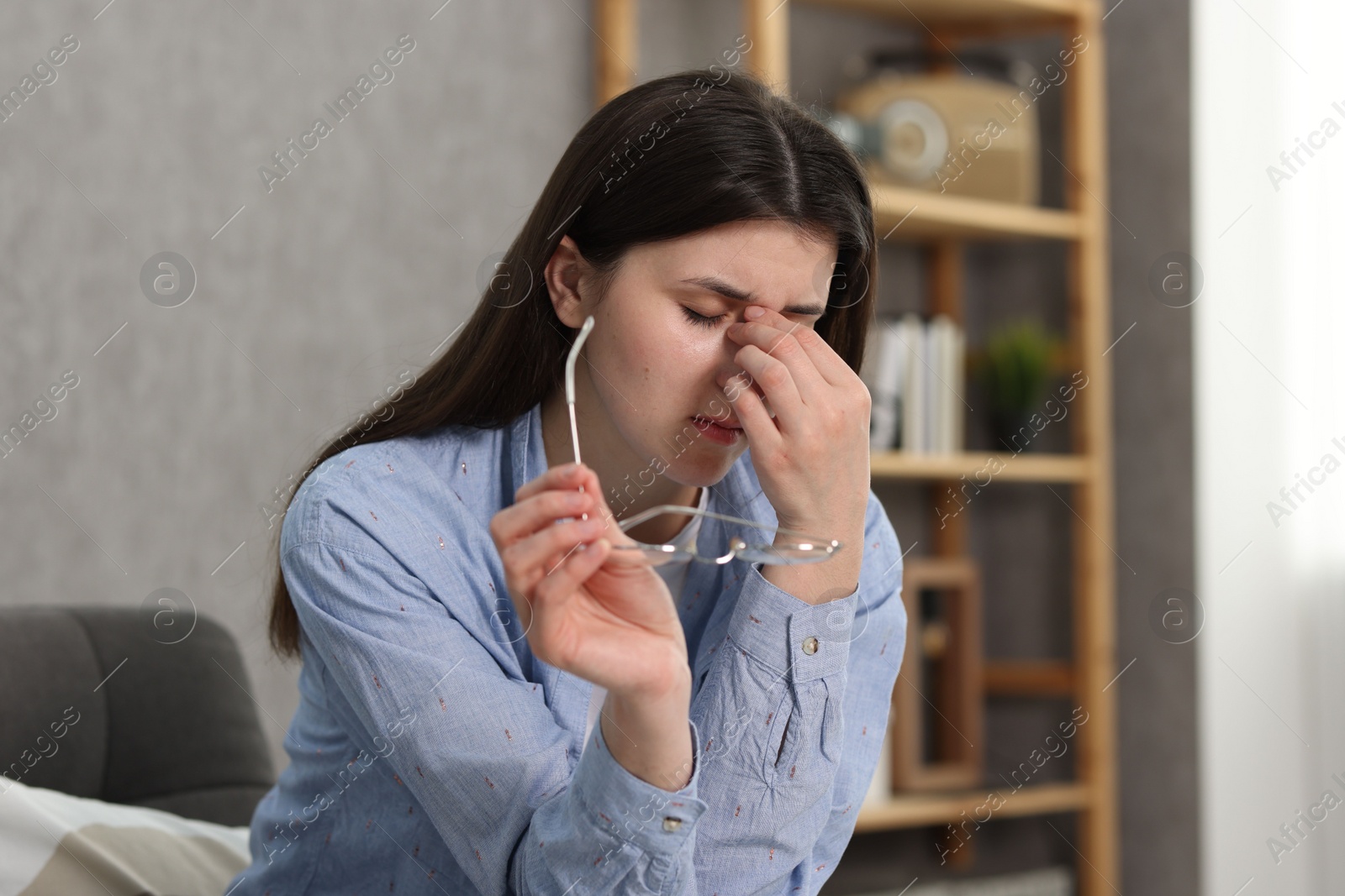 Photo of Overwhelmed woman with glasses suffering at home