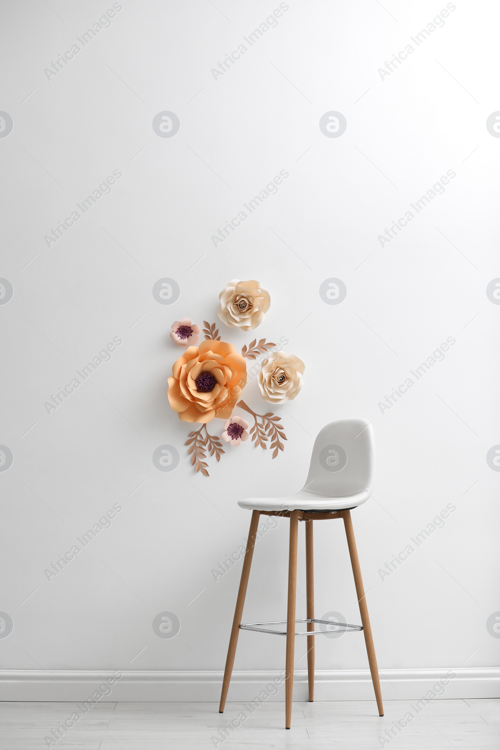 Photo of Stylish room interior with floral decor and bar stool