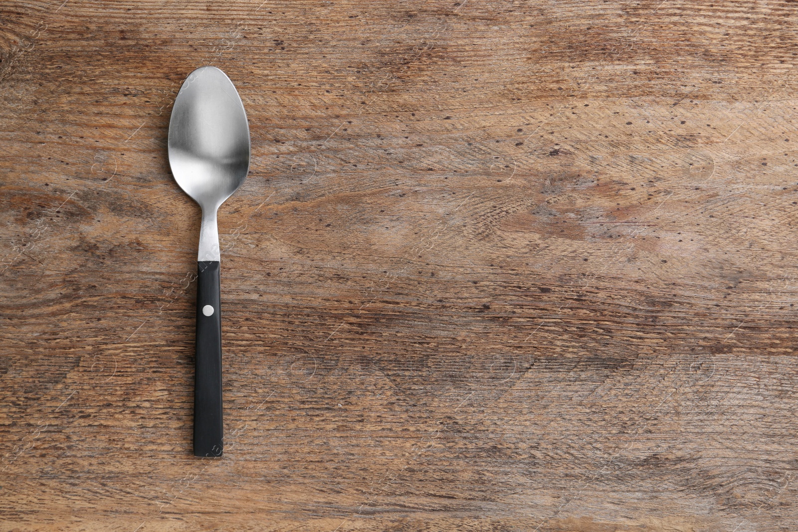 Photo of Clean empty table spoon on wooden background, top view. Space for text