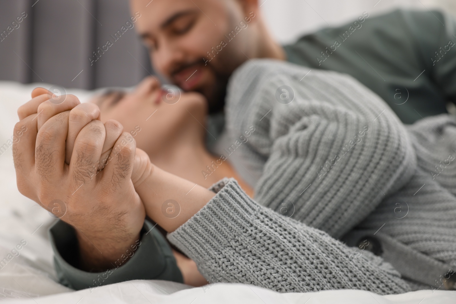 Photo of Affectionate young couple spending time together on bed, selective focus