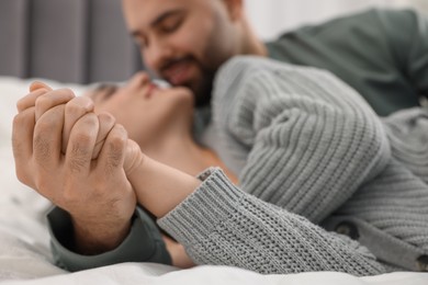 Affectionate young couple spending time together on bed, selective focus