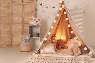 Modern children's room interior with play tent and lights