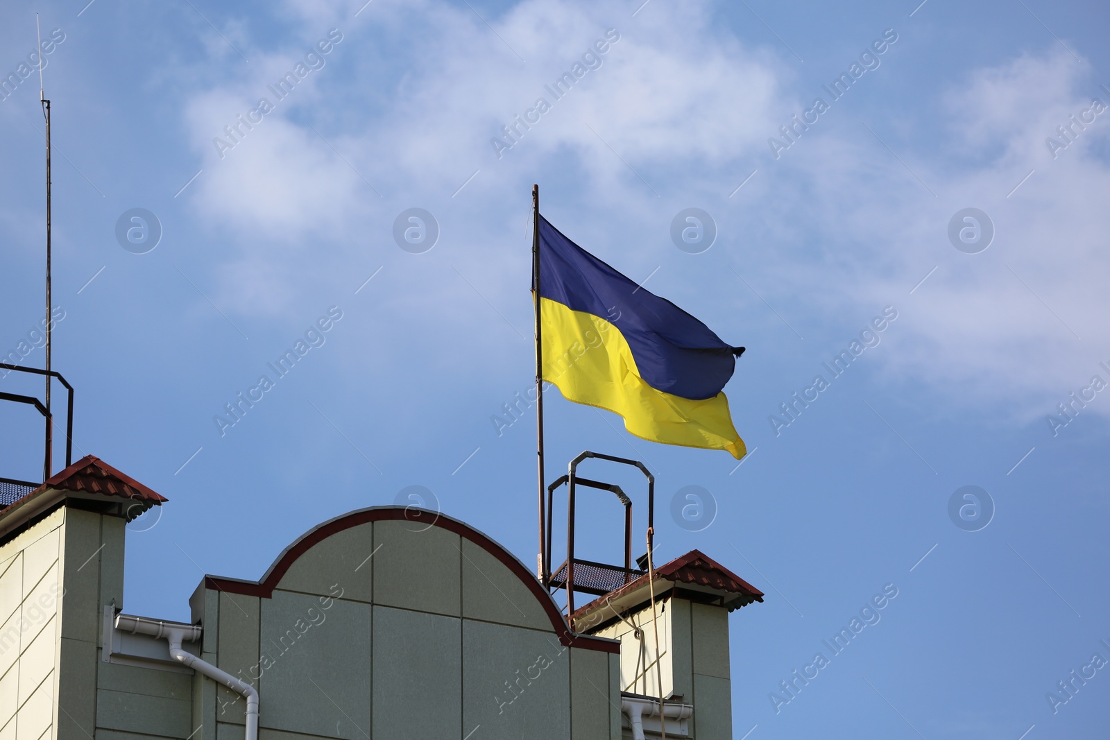 Photo of Ukrainian flag on building against blue sky